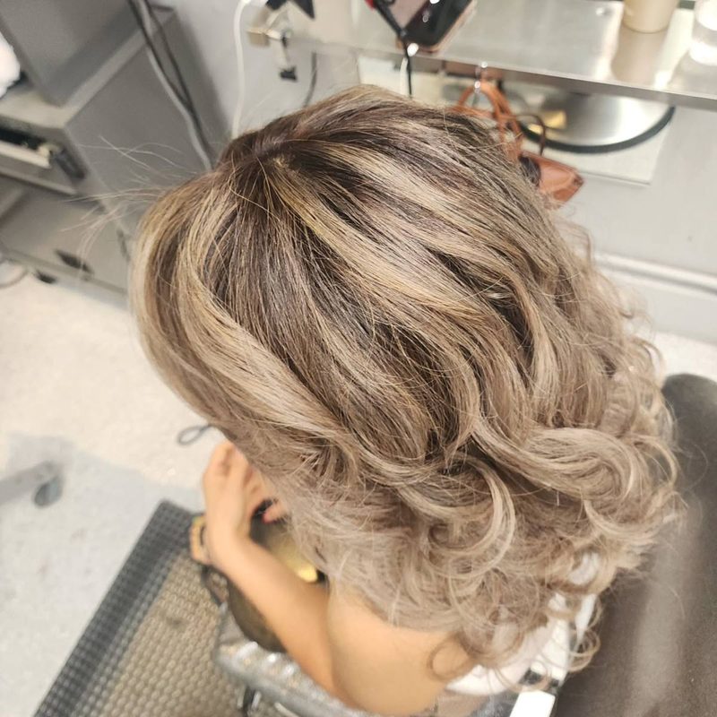 Ash blonde highlights on a short curly cut